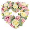 A delicate yet substantial heart-shaped wreath is shown against a crisp white background, every part of its outline filled with pastel flowers that evoke a sense of calm, like a quiet moment overlooking Primrose Hill at sunset. The arrangement is dense and carefully balanced, forming a complete heart with no gaps, just a continuous tapestry of petals and foliage. Soft cream and pale yellow roses serve as the main anchors, their rounded, velvety blooms opening in spirals that catch and hold the eye. Tucked closely around them are clusters of pastel pink carnations, their many frilled petals adding a plush, tactile richness, almost like finely gathered fabric. Interspersed among these are deeper pink and mauve lisianthus flowers, their open, gently curling petals and occasional darker centres lending depth and a gentle note of sophistication. Tiny yellow-green buds peek from between the larger flowers, signalling freshness and the fleeting beauty of new life. Woven throughout the design are strands of silvery-green eucalyptus, the round leaves adding an understated, cool-toned contrast that frames the heart and offers a sense of composure and peace. The overall mood is one of tenderness, sympathy, and quiet remembrance, making this design a meaningful choice for funeral services, graveside tributes, or memorial gatherings in the Primrose Hill and Regent's Park area. Crafted with the attentive hand of a local florist, it feels like a loving gesture from neighbours and friends-a floral embrace that honours memories while bringing a gentle softness to a difficult day.